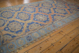 Distressed Soumac carpet detail with geometric borders and abrashed terracotta tones.