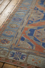 Handwoven Soumac carpet's textured surface with geometric panels and blue, terracotta shades.