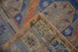 Folded detail of distressed vintage Soumac carpet, showcasing hand-woven texture and geometric patterns.