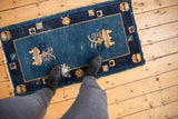 Antique Peking rug with faded cobalt blue field, double vase design, and visible foundation.