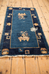 Antique Peking rug corner, blue field, pictorial cartouches, foundation wear, tattered fringe.