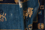 Antique Chinese Peking rug: cobalt blue hand-knotted pile showing wear, visible foundation.