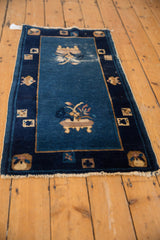 Worn fringe and corner of an antique Chinese Peking rug, showing pictorial cartouches and vase motif.