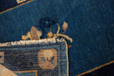 Antique Peking rug's folded corner, showcasing cobalt blue pile, natural fringe, and woven foundation.