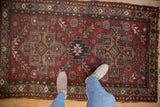 Distressed Mehrivan rug's serrated stepped medallion, floral field, and cherry red tones.