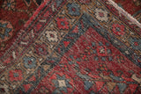 Close-up of vintage distressed Mehrivan rug pile, woven foundation, and fringe.