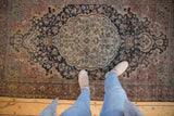 Distressed vintage Farahan Sarouk rug with an aged texture and elegant curvilinear floral patterns.