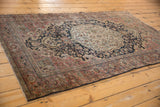 Distressed Farahan Sarouk rug showing soft colors, curvilinear floral pattern, and texture from wear.