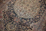 Curvilinear floral blossoms and vinery on dusty navy spandrel and antique ivory field with time-softened tones.