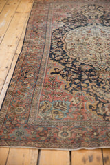 Distressed border of the vintage Farahan Sarouk rug, with dusty rose, blue motifs, and original side cord selvage.