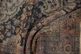 Distressed curvilinear floral patterns with worn pile in dusty navy, blush, and coffee.