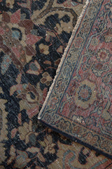 Distressed vintage Farahan Sarouk rug detail showing worn pile, visible foundation, and side cord selvage.