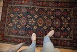 Fine Malayer rug, with worn navy field, allover oversized floral top-view design, and red border.