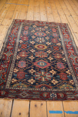 Vintage Malayer rug's navy field with worn oversized floral motifs and red samovar border.