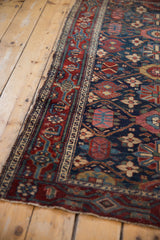 Hand-knotted vintage Malayer rug's deep red samovar border and navy blue field with floral motifs.