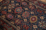 Hand-knotted Malayer rug detail with navy field, worn stylized floral motifs, and vinery border.