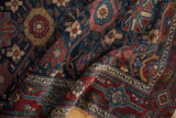 Folded Malayer rug detail: allover floral pattern, samovar border, navy, red, and gold.