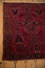 Raspberry red Sarouk rug with dense, thousand flower inspired indigo vase motif.