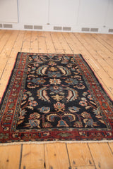 Detail of vintage Bibikabad rug with dramatic Herati-like navy blossoms, burgundy border, and gentle pile wear.