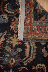 Vintage Bibikabad rug's textured navy pile, blue-green motifs, restored side cord, and woven back.