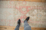 Distressed Oushak runner showing faded asymmetric medallion, pale pink, ivory, and blue pile.