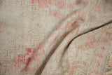 Distressed texture of ivory and blush pink pattern with visible foundation and short fringe.
