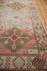 Distressed Oushak runner with serrated medallion and geometric floral border motifs in blush, ivory, bronze.
