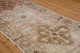Distressed texture of vintage Oushak runner with faded blush, ivory, and bronze tones.