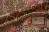 Distressed pile showing dusty rose and bronze geometric motifs on a vintage Oushak runner.
