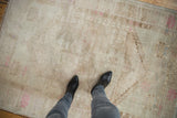 Distressed Oushak rug with muted ivory, beige, pink tones and faint patterns.