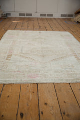 Fringe detail and soft, distressed Oushak rug pile with muted pink tones.