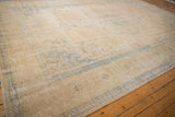 Vintage Distressed Oushak carpet with evenly worn ivory pile and faded blue border.