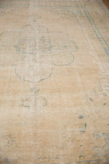 Distressed texture of a vintage Oushak rug with faded ivory and pale denim blue patterns.