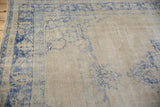Detail of the distressed Oushak's hand-knotted pile showing mostly even wear in cobalt blue and beige.