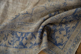 Softly folded Oushak carpet showing the distressed texture and low-pile, hand-knotted weave.
