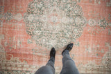 Distressed vintage Sparta rug, dusty terra cotta field, green floral pattern, visible foundation.