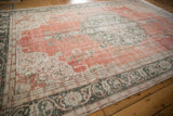 Distressed Sparta carpet border shows mostly even wear, dusty terra cotta, and green vine.