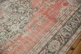 Distressed Turkish Sparta carpet detail with meandering green vine border and scrolling arabesques.