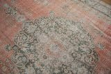 Distressed dusty terra cotta and deep green arabesque motifs on a Sparta carpet.