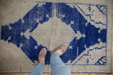 Distressed cobalt blue medallion on an abrashed ivory field with checkered striations.