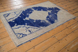 Close-up of the distressed Oushak rug's intact side selvage and worn cobalt blue pattern.