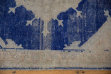 Vintage distressed Oushak rug detail: worn cobalt blue pattern contrasting with abrashed neutral field.