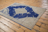 Distressed beige field, cobalt blue pattern details, and secured side selvage.
