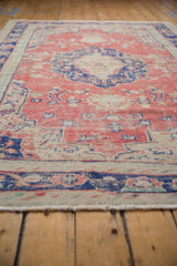 Soft ivory fringe and distressed edge with faded brick red and navy on this vintage Oushak rug.
