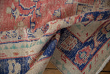 Distressed Oushak rug's worn pile texture, faded brick red, navy blue, pale turquoise, ivory.