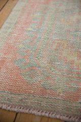 Distressed vintage Oushak rug's worn pile texture in pale pink, seafoam green, and ivory.