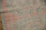 Distressed pile texture with faded pale pink and seafoam green Rococo motifs.