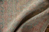 Distressed hand-knotted Oushak rug pile, revealing wear with pale pink and seafoam accents.