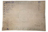 Vintage distressed Oushak carpet with ivory open field, abrashed roundel medallion and blue spandrels.