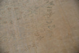 Distressed Oushak carpet pile showing mostly even wear and faded beige tones.